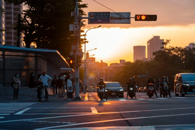 the sun is going down over a busy street