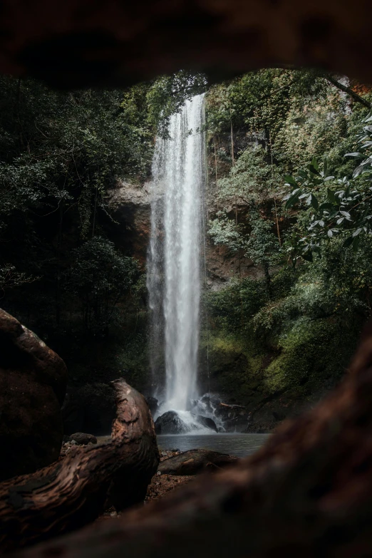 an open cave, with a waterfall in the background