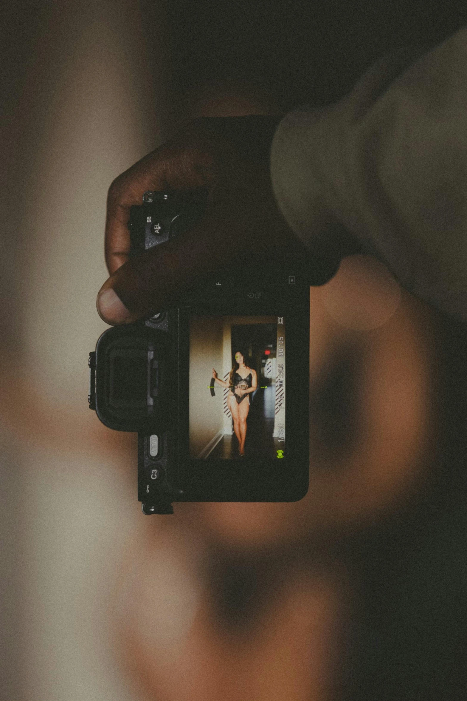 the woman is holding up a black camera