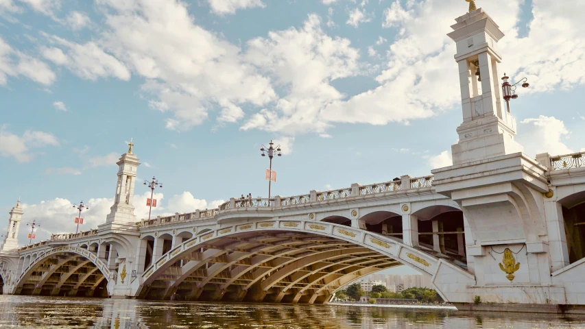 a bridge over a body of water with a clock tower at the end