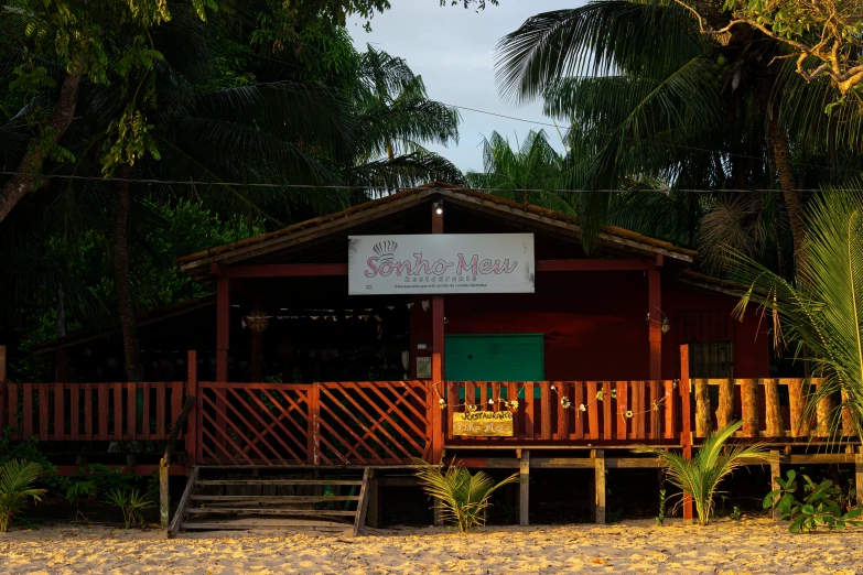 a tropical beachfront cabin with a sign and trees