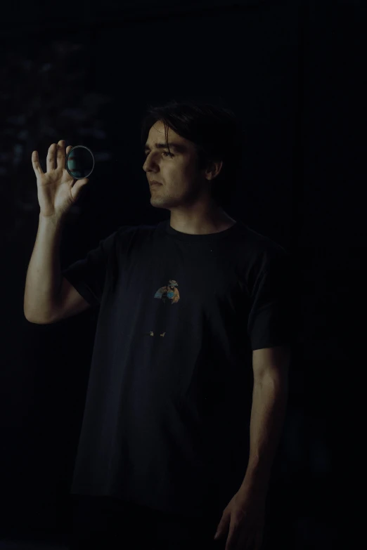 a man is standing in the dark and holding a strange object