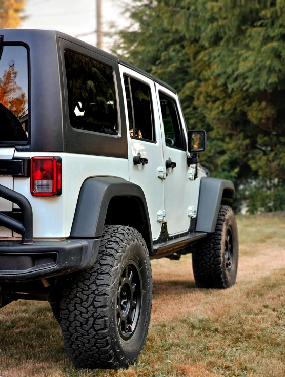 a jeep is parked in the grass near trees