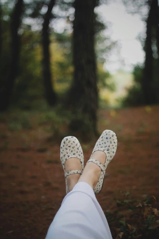 a person's feet with a pair of white shoes