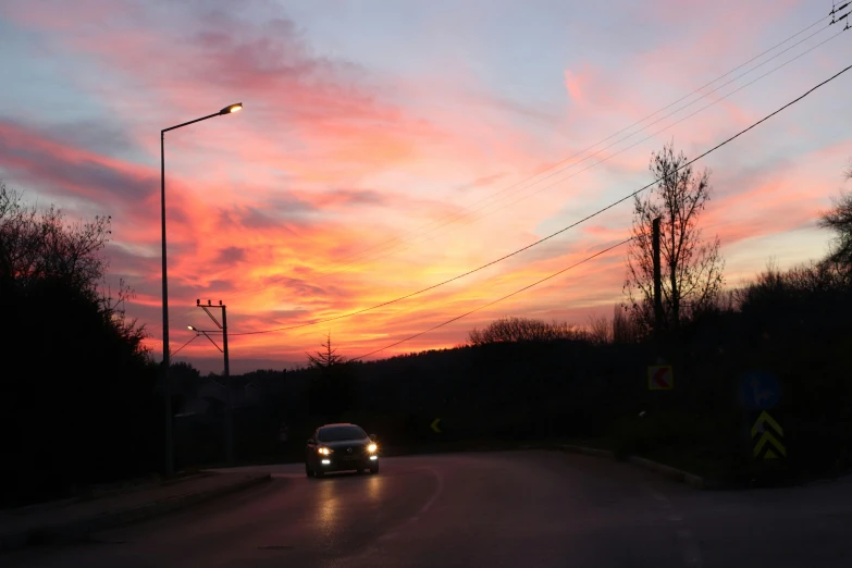 a car is driving at sunset on a street