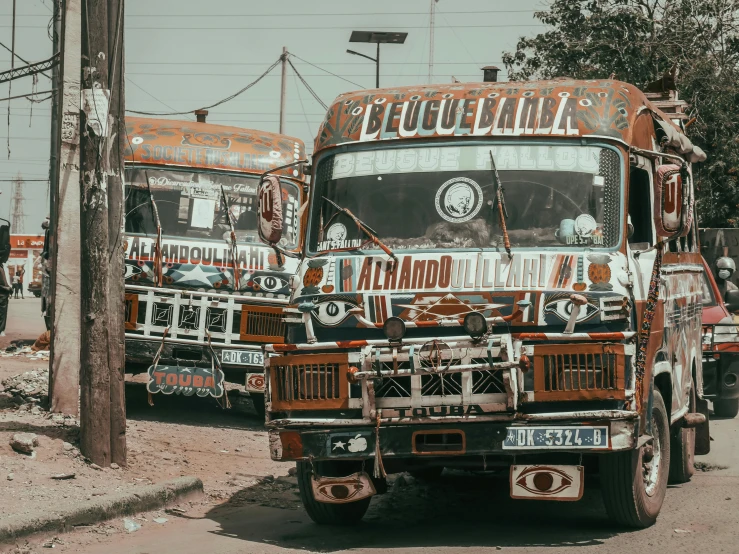 two rusty buses parked on the side of the road