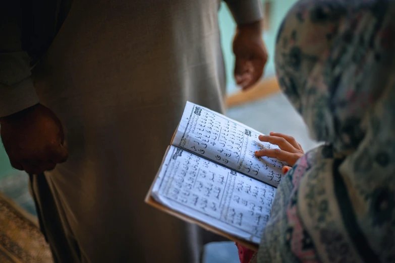 a woman holding a book up with her hands