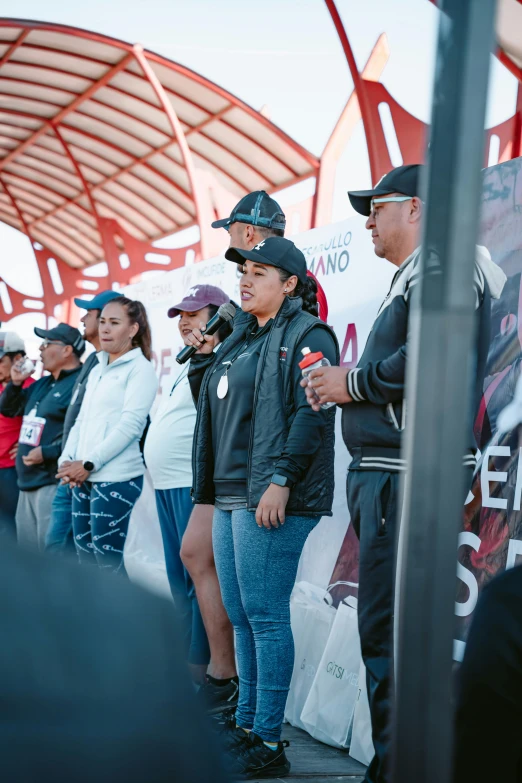 a group of people standing near each other with some wearing hats