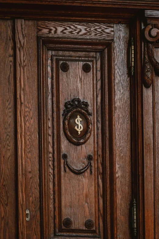 a wooden door with some fancy metal handles