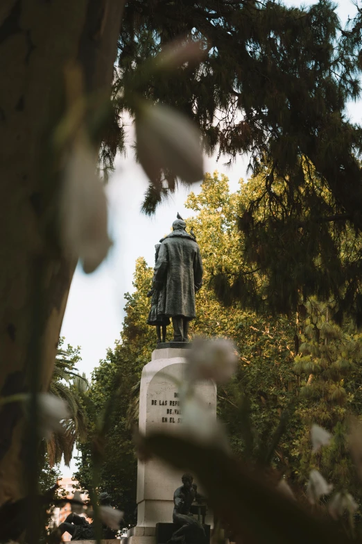 the statue is in a park area with trees in the background