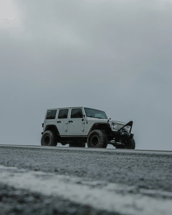 the jeep is off - roading with its tire being lifted