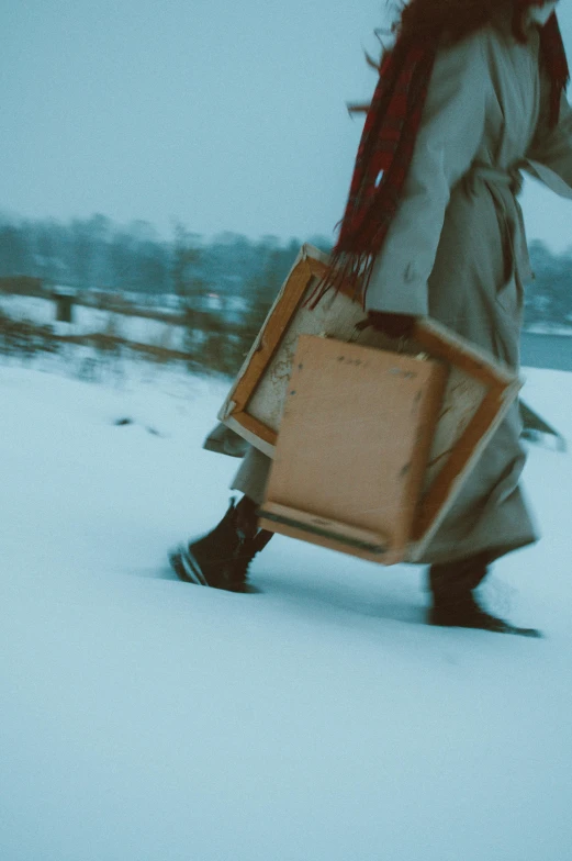 a person with two suitcases running in the snow