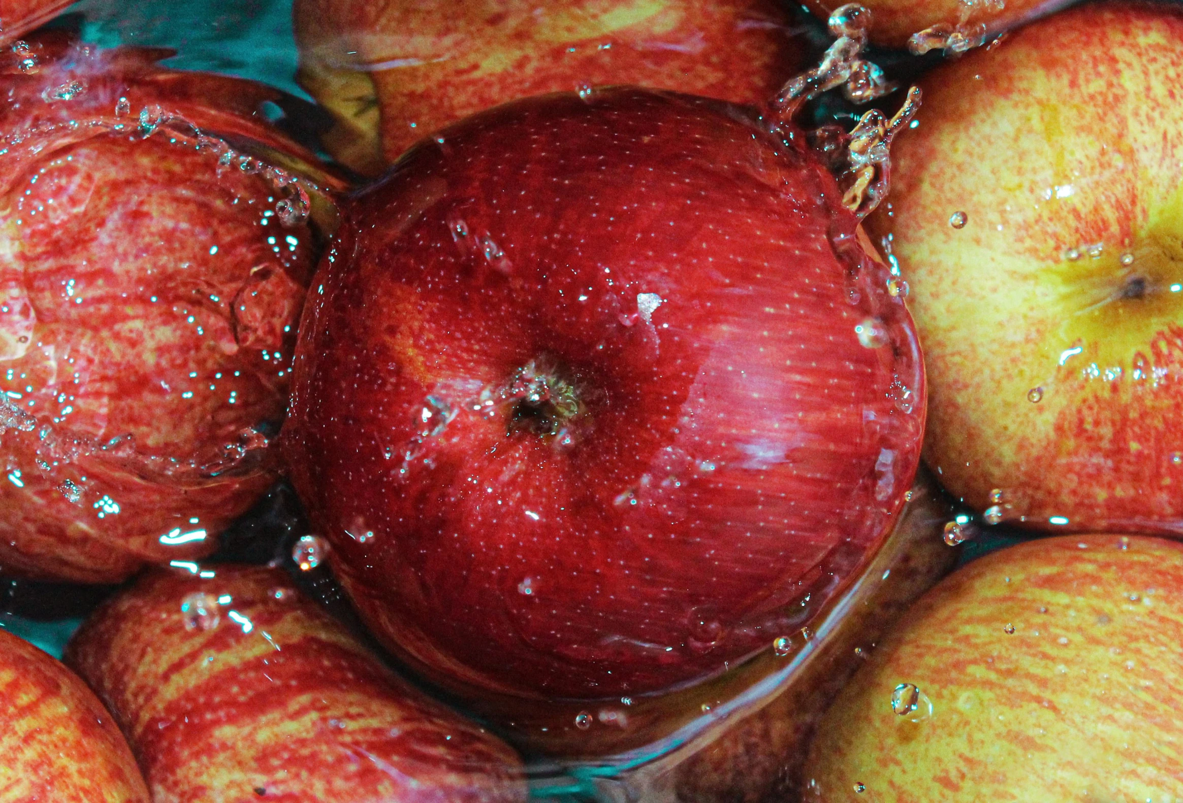 closeup of some apples in water on a table