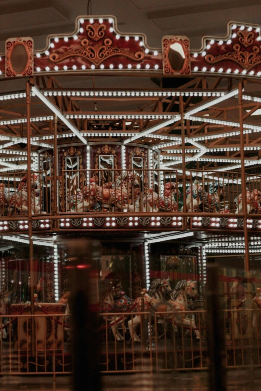 a large carousel with many carousel horses is illuminated up