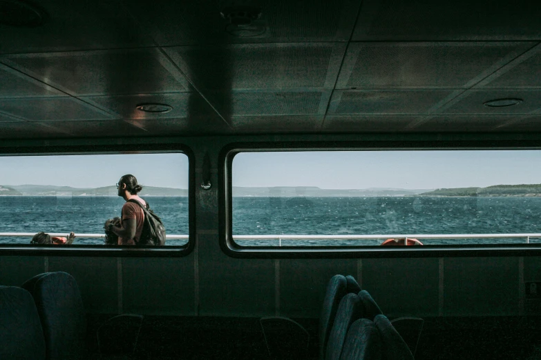 a woman and a boy are looking out the window of a boat