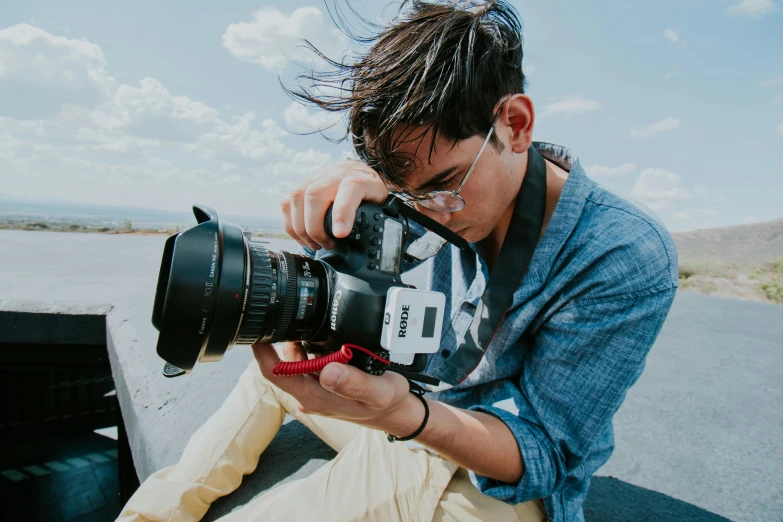 a man with sunglasses on taking a pograph with his camera