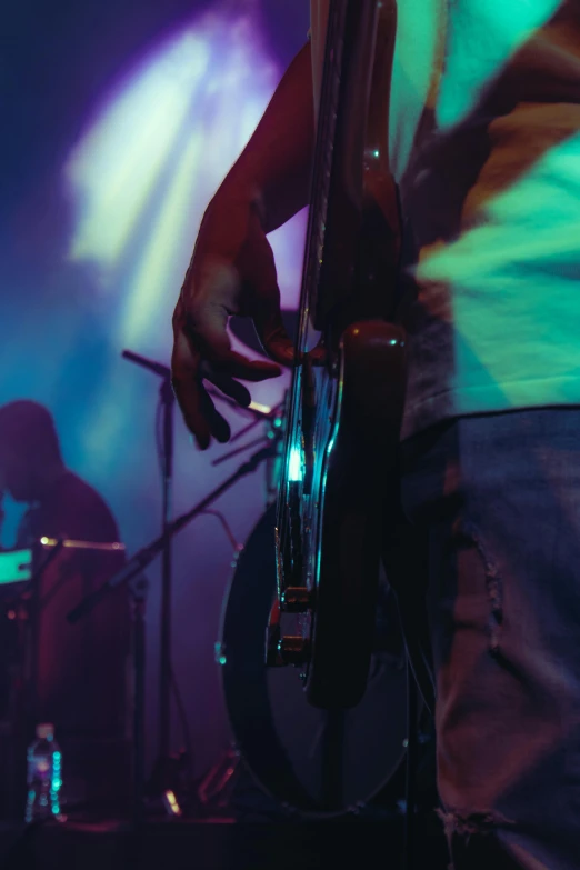 man with guitar playing on stage at night
