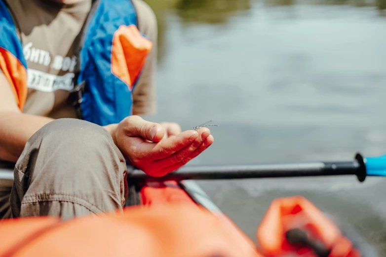 person in a kayak with a cigarette in their hand