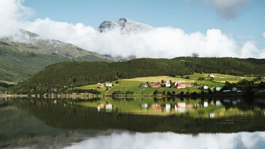 a small town by the water surrounded by mountains