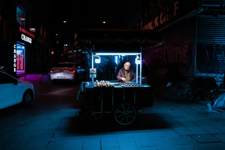 a man selling food on the street at night