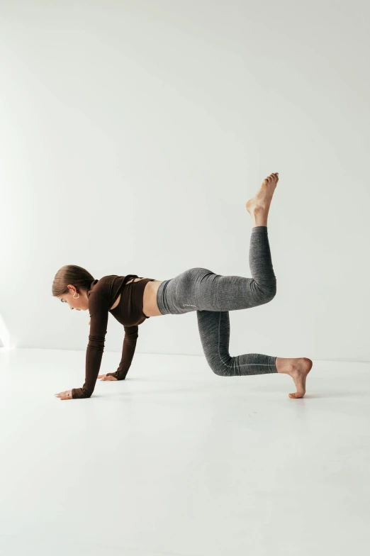 a woman doing a side plank exercise in grey