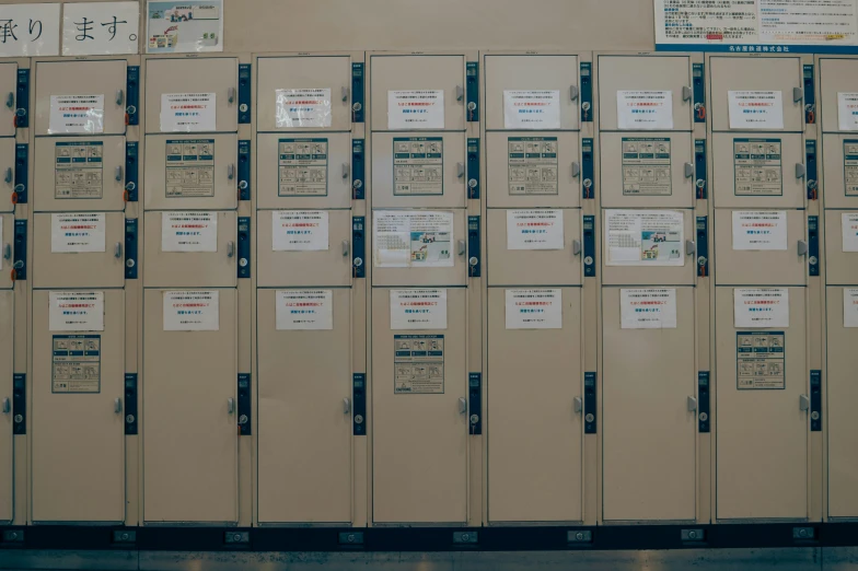 several beige metal lockers with paper labels attached