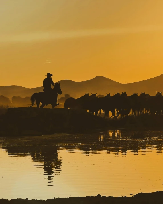 people ride horses across a bridge over a body of water