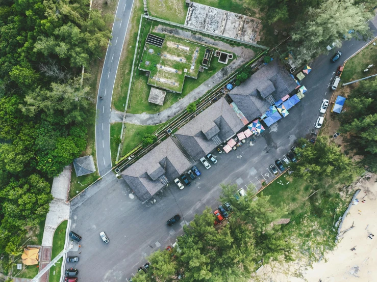 an overhead view of a small area of parking lot with cars parked at one end