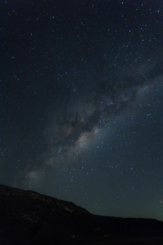 the stars can be seen above a grassy hillside