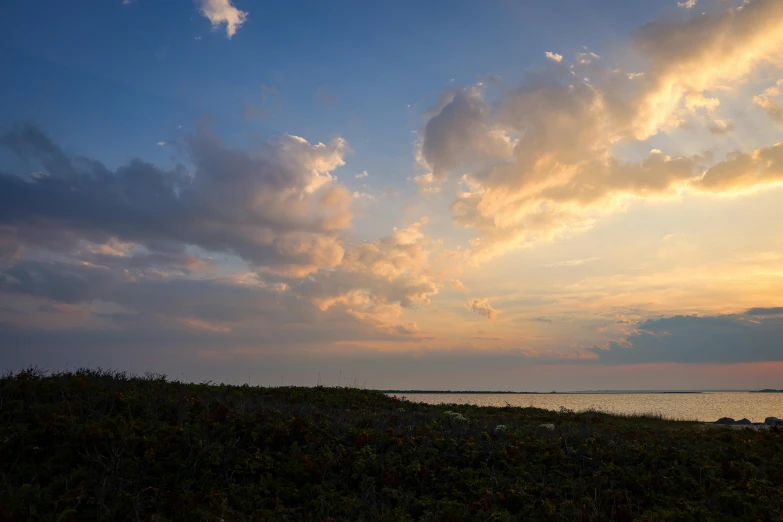 an ocean with clouds rolling over the shore