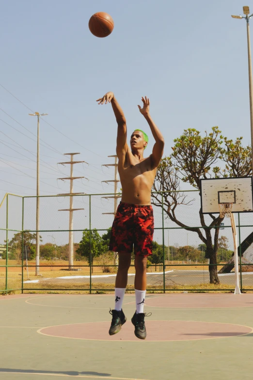 man leaping up to catch the basketball as he jumps up