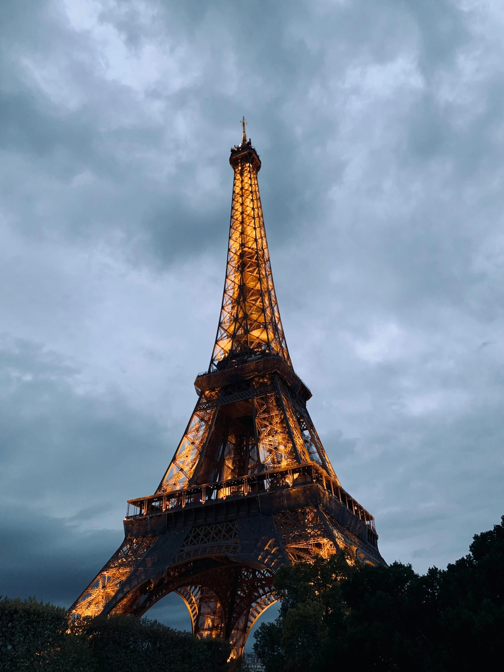 the eiffel tower at night is lit up in gold