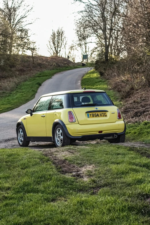 a mini with a yellow top driving down the road