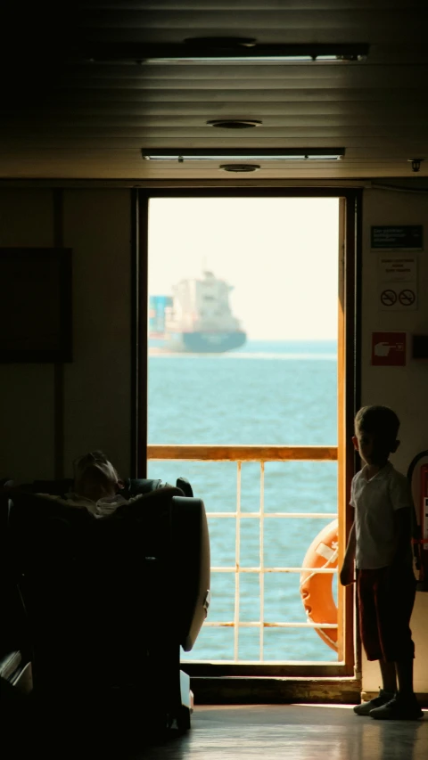 two young children watching the ocean from inside a house