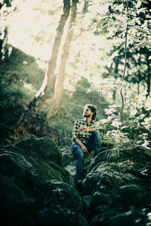 a man that is sitting on a rock