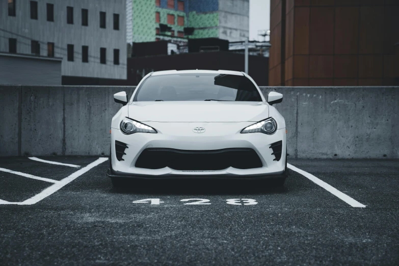 a white sports car parked in a parking spot