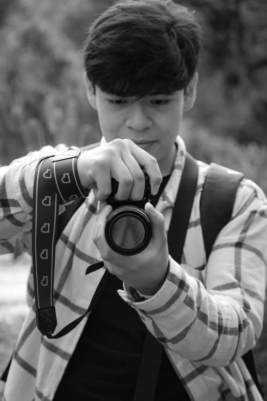 black and white pograph of boy holding up camera