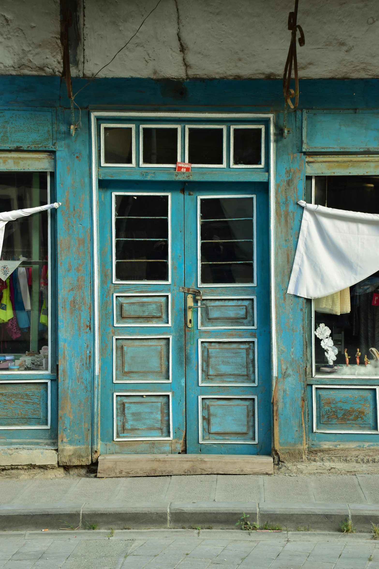 clothes hanging on a rope outside of a building with blue doors