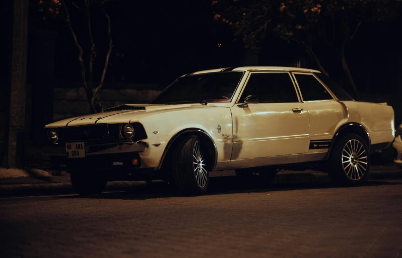 a white station wagon is parked at night