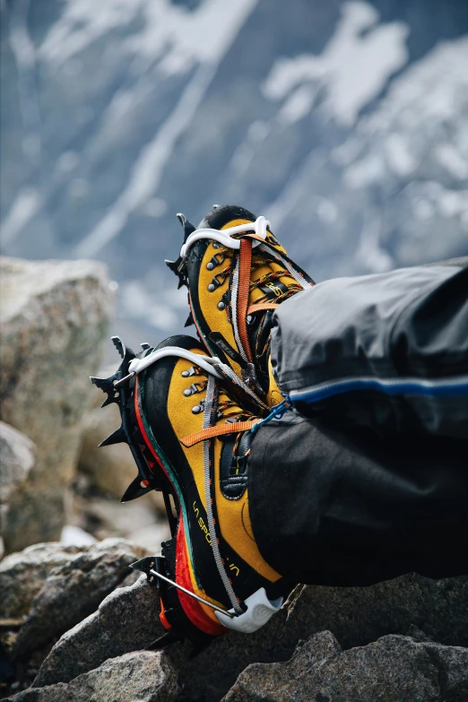 two pairs of shoes with spikes on them sitting on some rocks