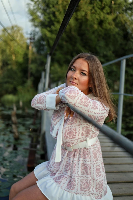 a woman is posing with her hand on her shoulder