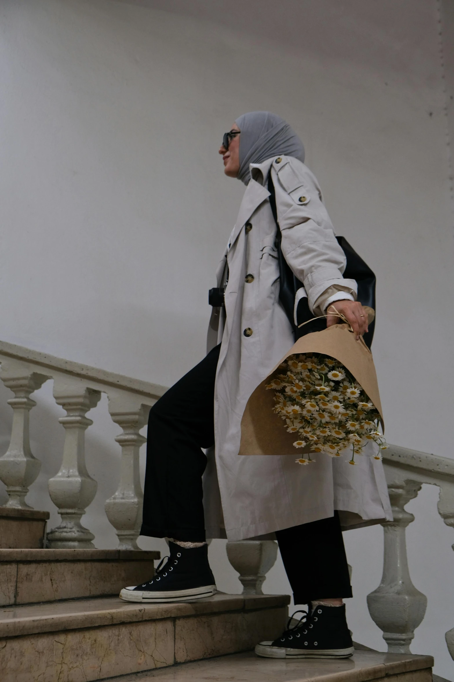 a man is walking up some stairs holding flowers