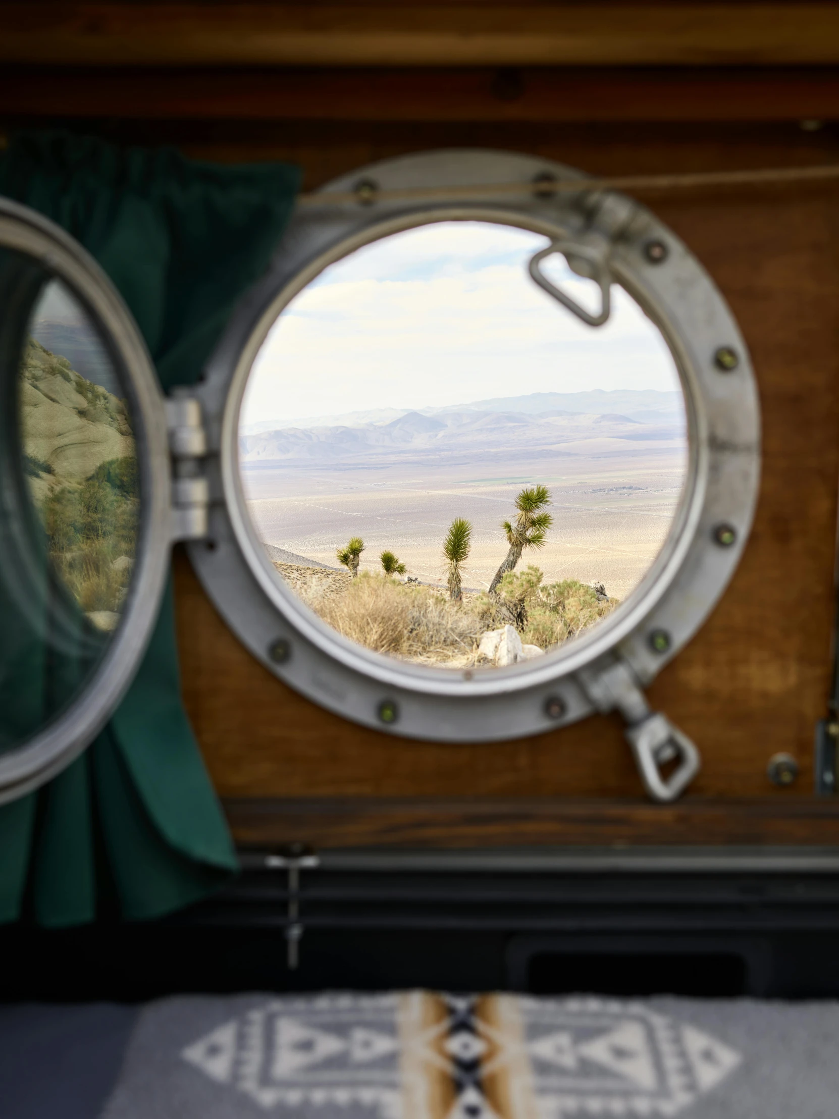 view from inside a boat with a porthole window, looking out onto the desert