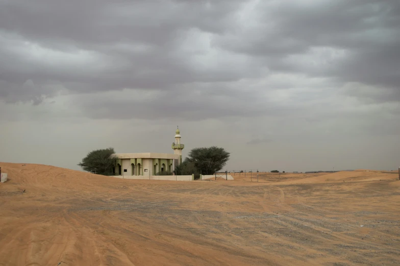 small building on top of a sandy hill