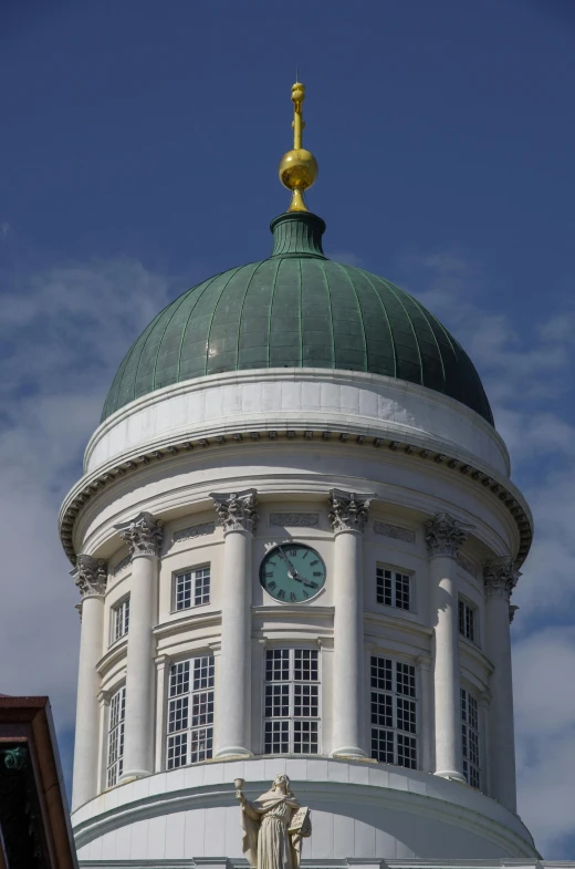 a clock tower with a statue on the roof of it