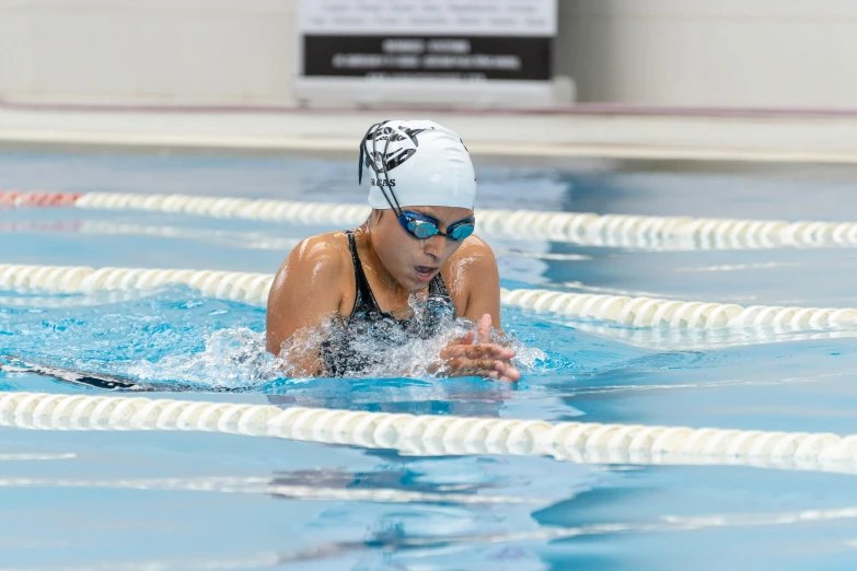 a swimmer that is wearing goggles and swimming in the pool