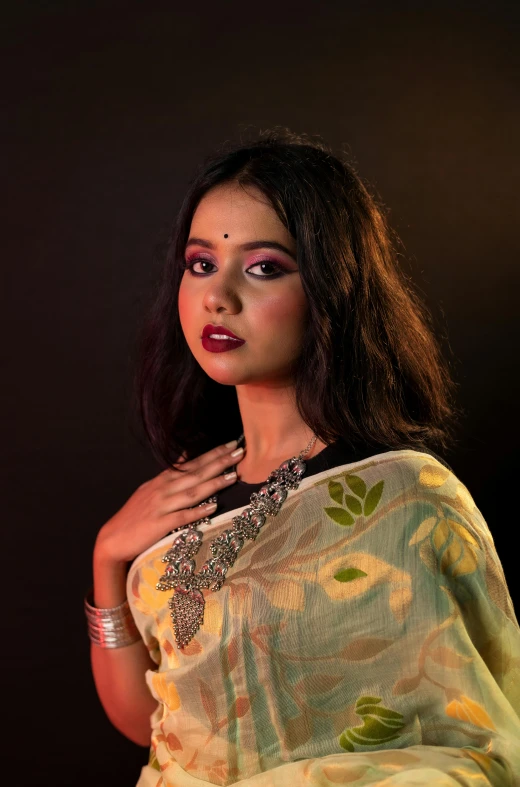 indian woman with dark hair wearing a yellow floral saree