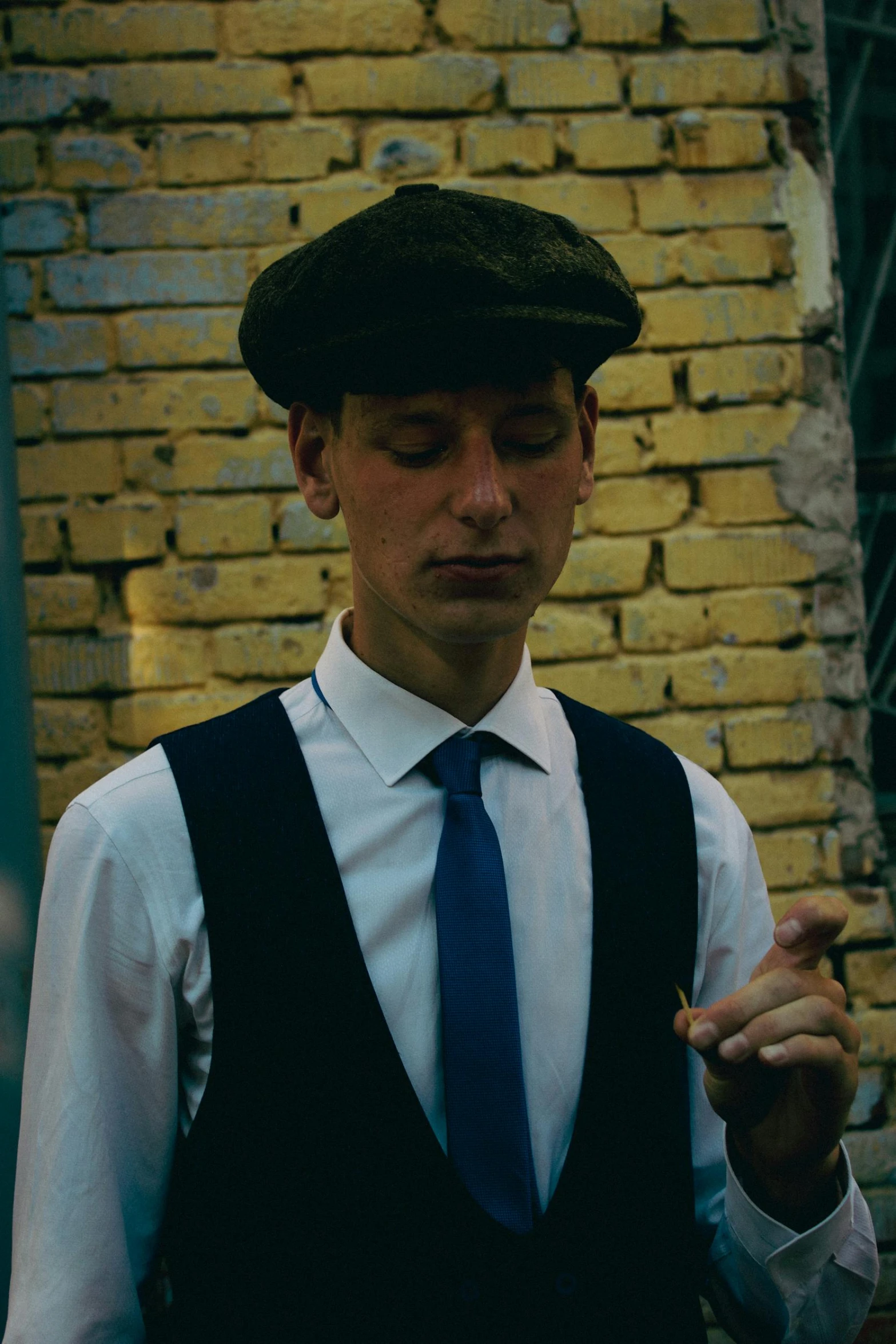 a man wearing a vest, tie and black hat