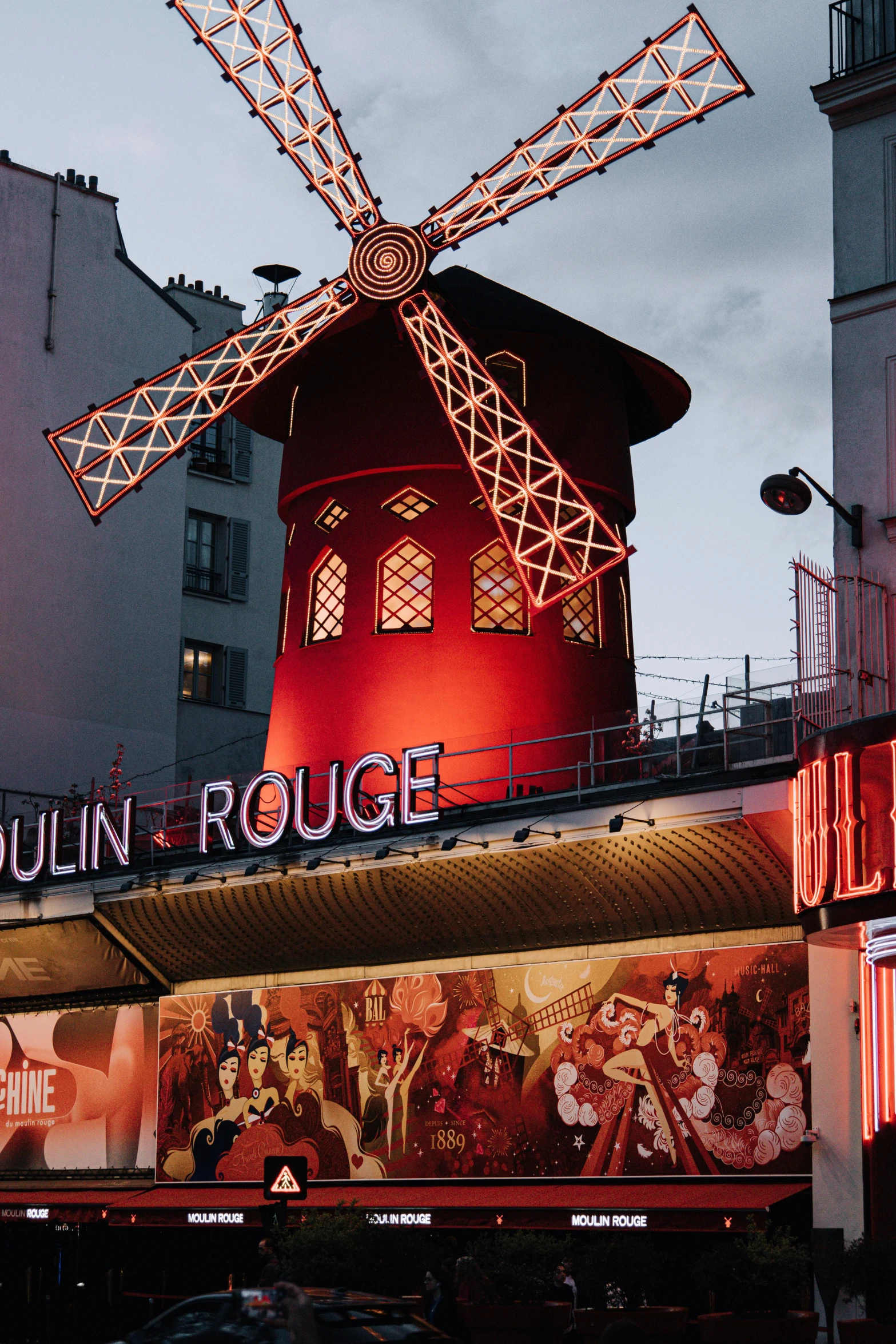 a huge windmill lit up above some buildings