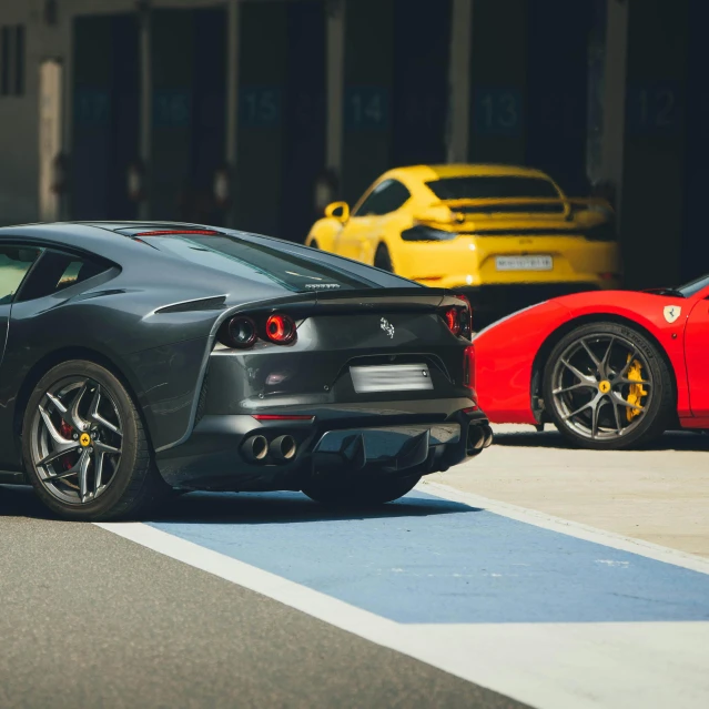 the red sports car is parked next to the gray sports car